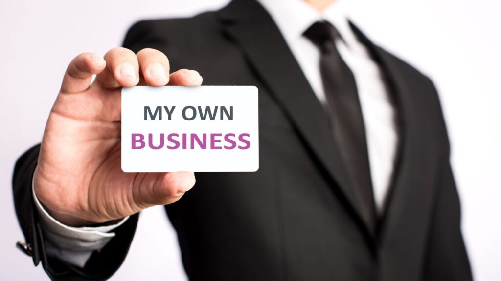 Obrazek przedstawia mężczyznę w garniturze trzymającego swoją wizytówkę