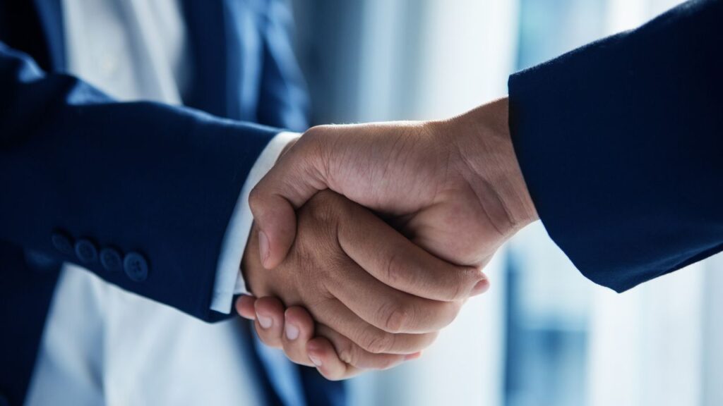 Obrazek przedstawia uścisk dłoni dwóch mężczyzn